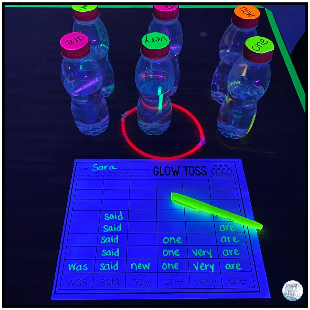 Six bottles with sight words on the lids, set up to play "Glow Toss."